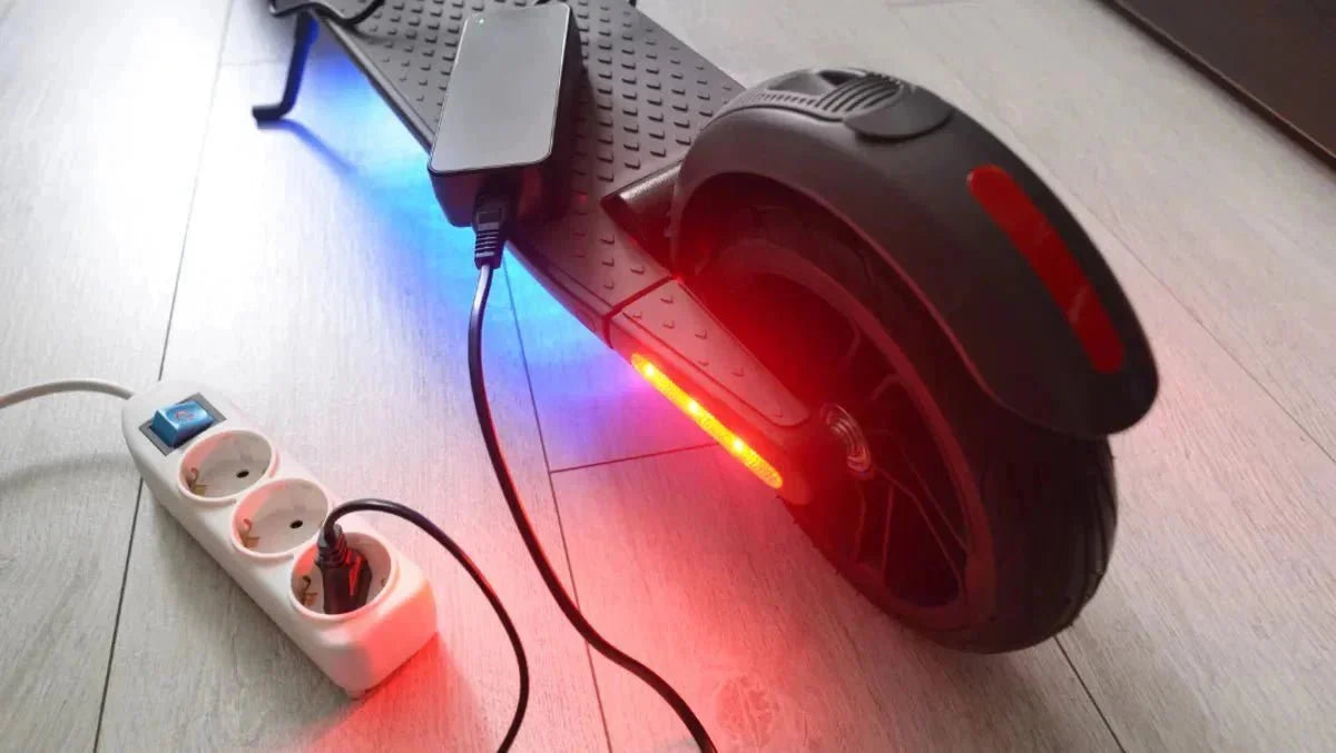 Trottinette électrique en charge à l’intérieur, chargeur branché sur une multiprise – augmenter l’autonomie