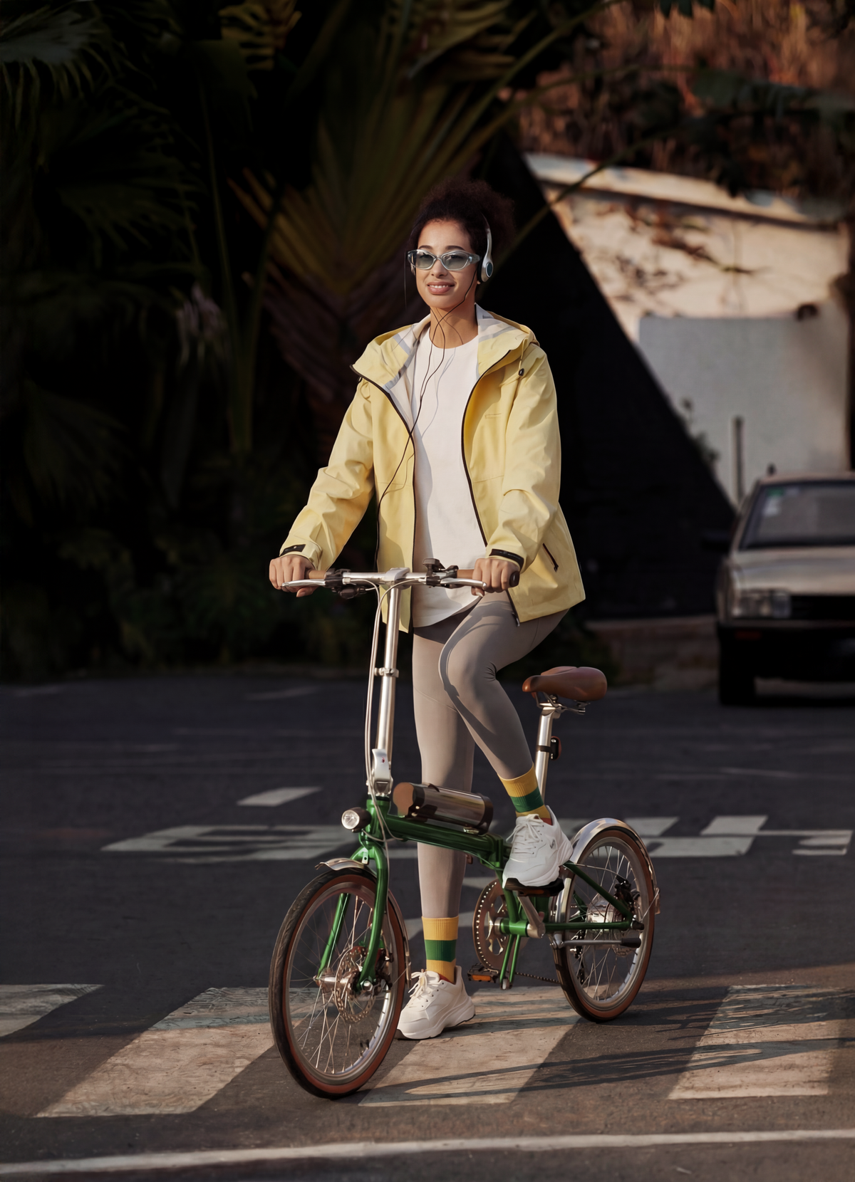 Femme roulant sur le vélo électrique pliant OneSport OT02 Pro coloris vert dans une ambiance nocturne