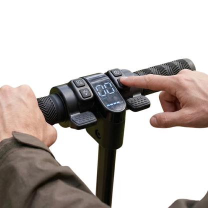 Gros plan sur le guidon avec écran et boutons, un doigt appuyant sur un bouton