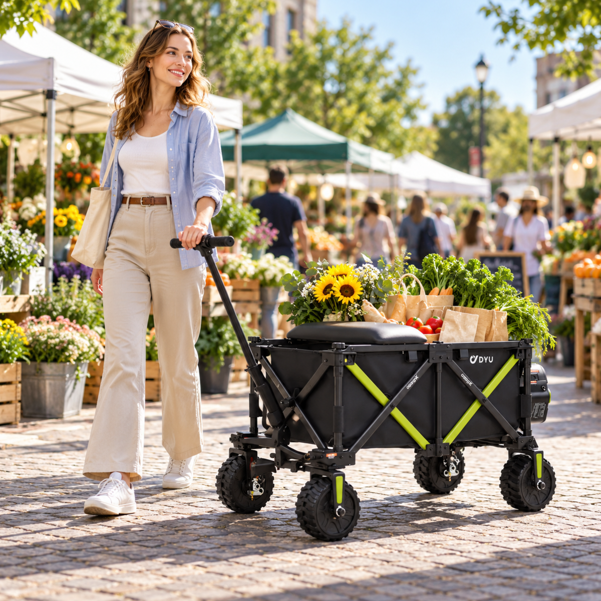 Une femme tire le chariot DYU CampX sur un marché, avec des fleurs et des sacs de courses dessus