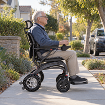 Homme âgé assis dans le fauteuil roulant électrique EASWE B10 dans un parc