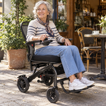 Femme âgée assise dans le fauteuil roulant électrique EASWE C20 dans un jardin