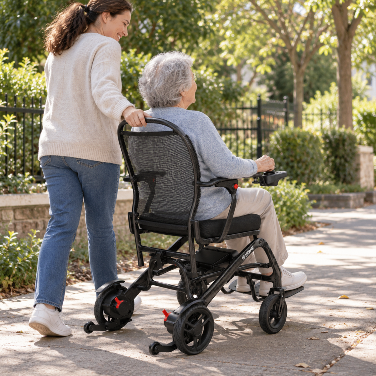 Femme poussant une personne âgée dans le fauteuil roulant électrique EASWE C20 dans un jardin
