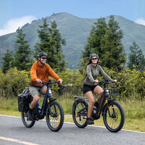 Deux personnes avec le vélo électrique fat bike ENGWE E26 3.0 PRO sur la route en montagne