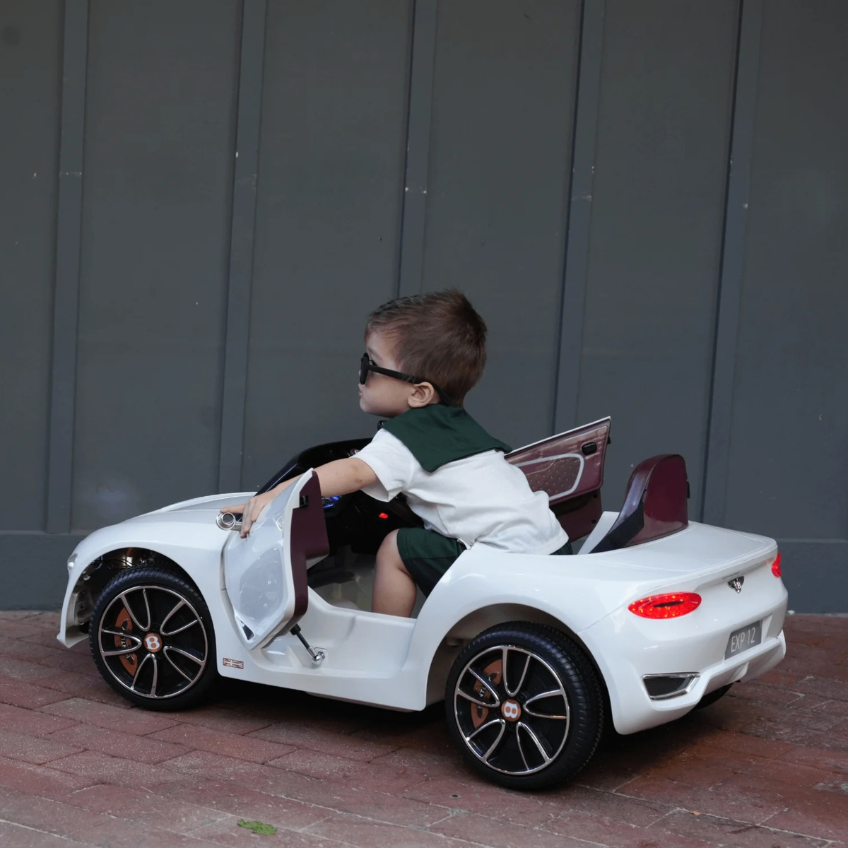 Enfant au volant de la voiture électrique pour enfants Bentley EXP 12