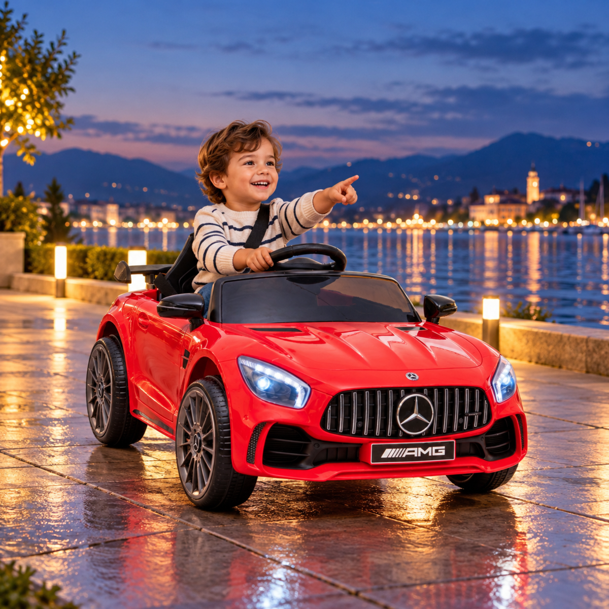 Enfant au volant de la voiture électrique pour enfants Mercedes AMG GT au bord de la mer