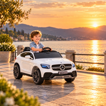 Enfant au volant de la voiture électrique pour enfants Mercedes GLC Coupé au bord de la mer