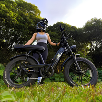 Femme roulant sur le vélo électrique fat bike TST R7 coloris noir sur une pelouse