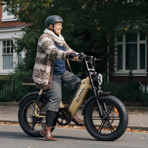 Personne roulant sur le vélo électrique fat bike TST R7 coloris beige dans une rue