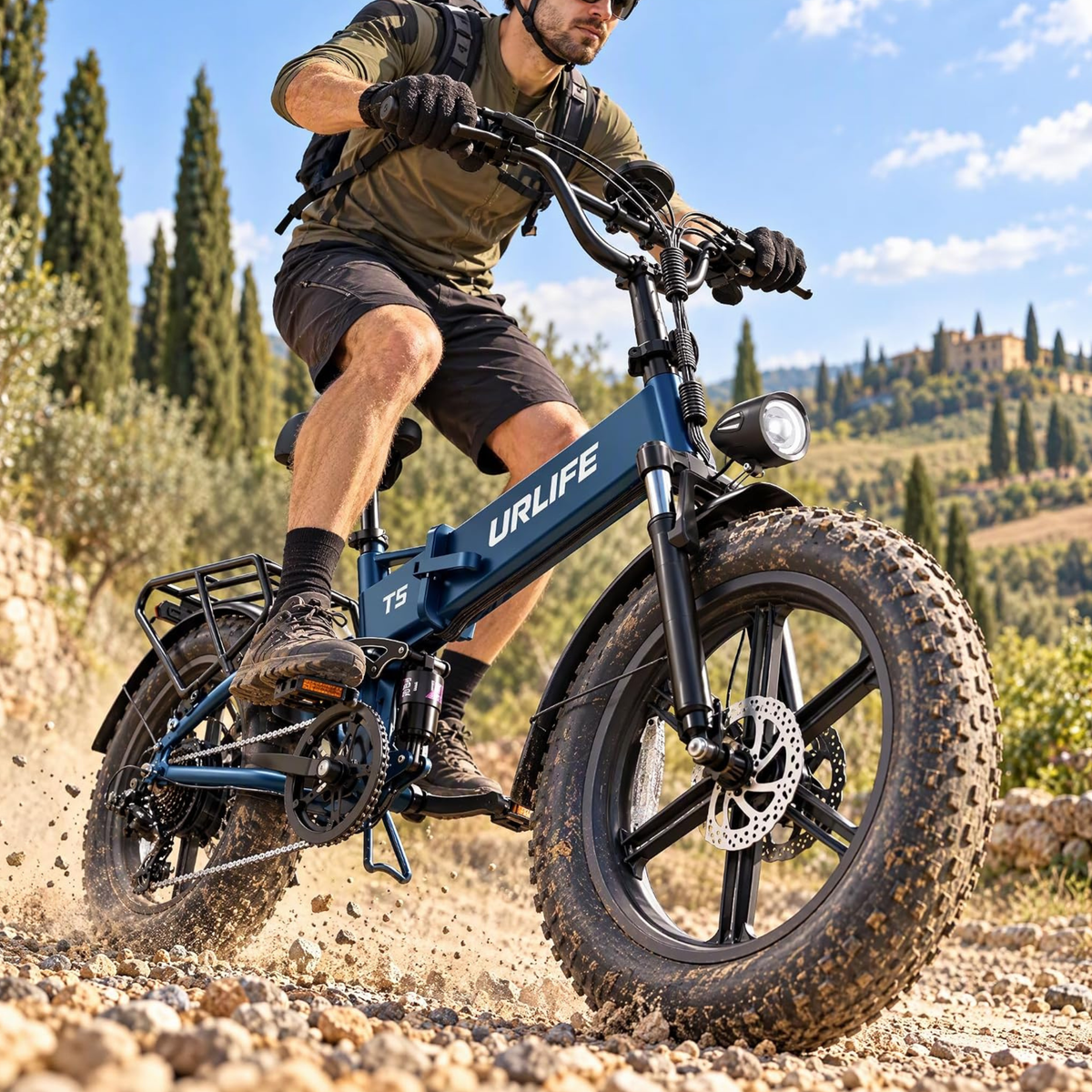 URLIFE T5 vélo électrique bleu à pneus larges conduit par un homme sur un chemin de gravier