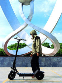 Homme roulant sur la trottinette électrique DriveTron DT01 en ville