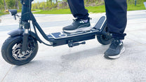 Personne roulant sur la trottinette électrique DriveTron DT01 dans une rue