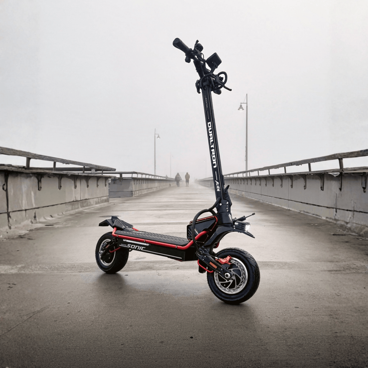 Trottinette électrique DUALTRON Alien vue de trois-quarts avant sur un pont