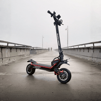 Trottinette électrique DUALTRON Alien vue de trois-quarts avant sur un pont