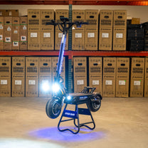 Trottinette électrique DUALTRON THUNDER 3 vue de trois-quarts avant avec les feux allumés en intérieur