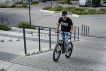 Homme roulant sur le VTT électrique Duotts E29 sur une allée