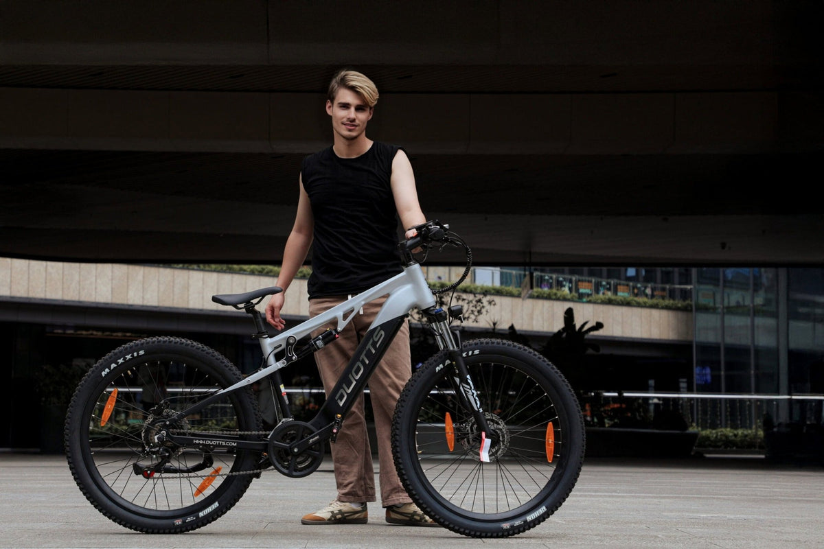 Homme debout avec le VTT électrique Duotts E29