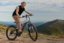 Homme debout avec le VTT électrique Duotts E29 sur une pelouse