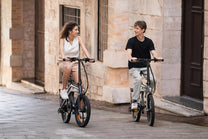 Deux personnes avec le vélo électrique pliant DYU T1 en ville