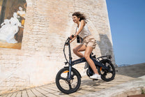 Femme roulant sur le vélo électrique pliant DYU T1 en ville