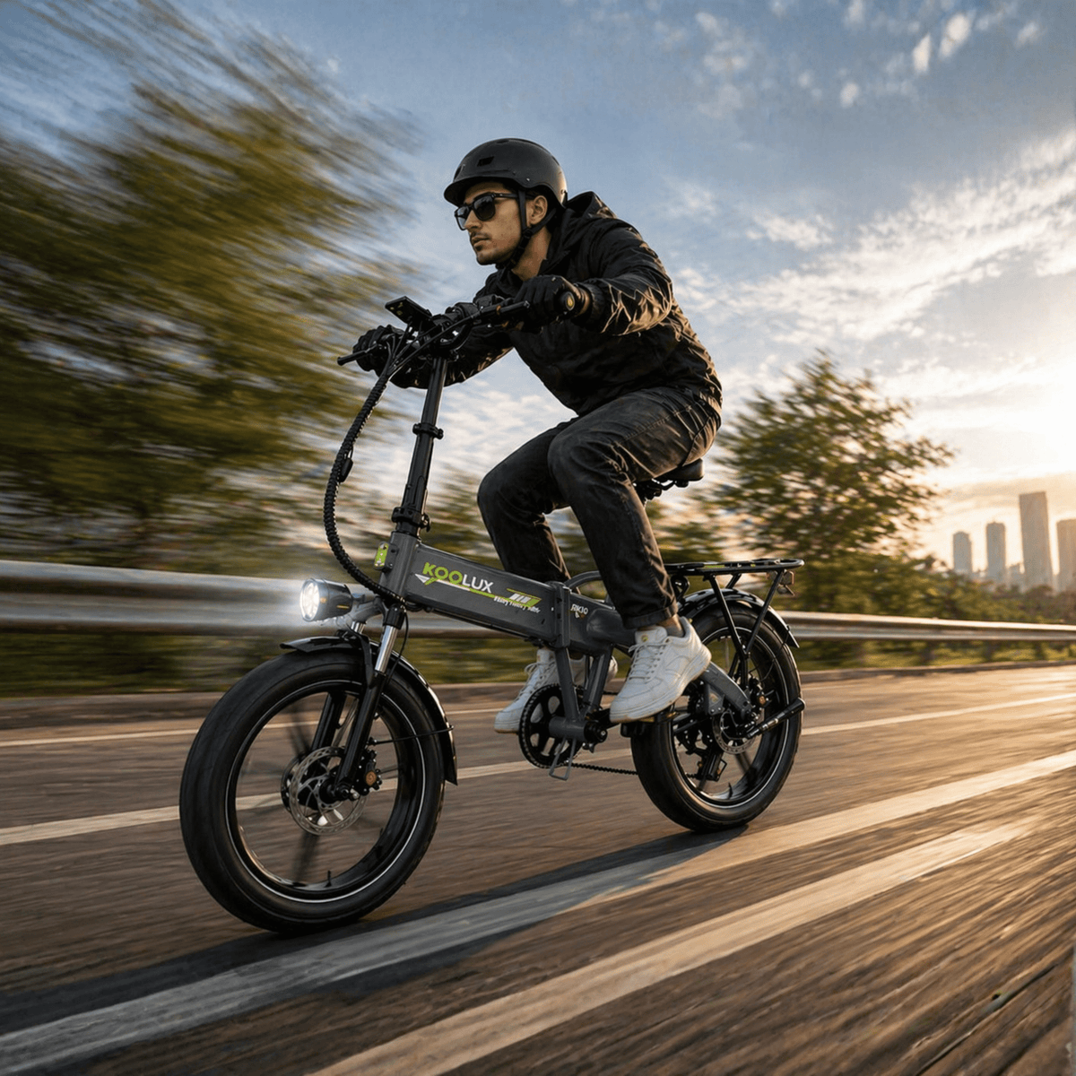 Homme roulant sur le vélo électrique pliant fat bike KOOLUX RK10 sur la route au coucher du soleil
