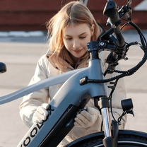 Femme debout avec le vélo électrique KOOLUX X3 en ville
