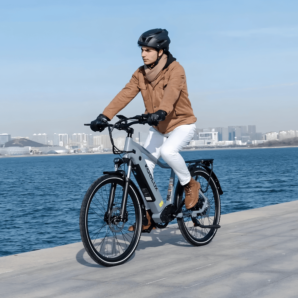 Homme roulant sur le vélo électrique KOOLUX X3 au bord de la mer