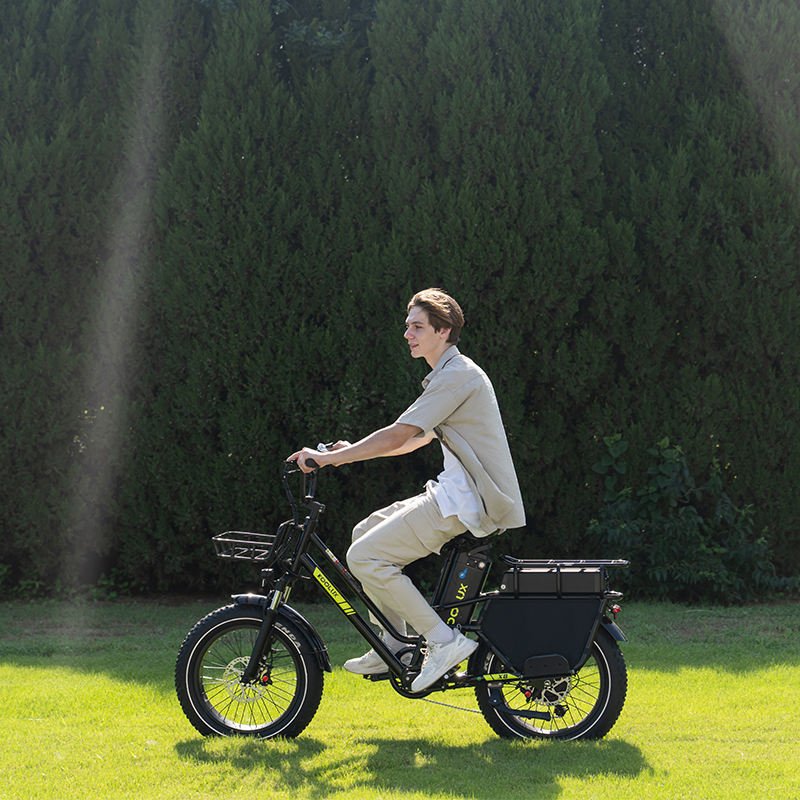 Homme roulant sur le vélo électrique fat bike KOOLUX X8 sur une pelouse