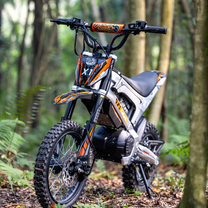 Personne debout avec la moto-cross électrique KuKirin X1 en forêt