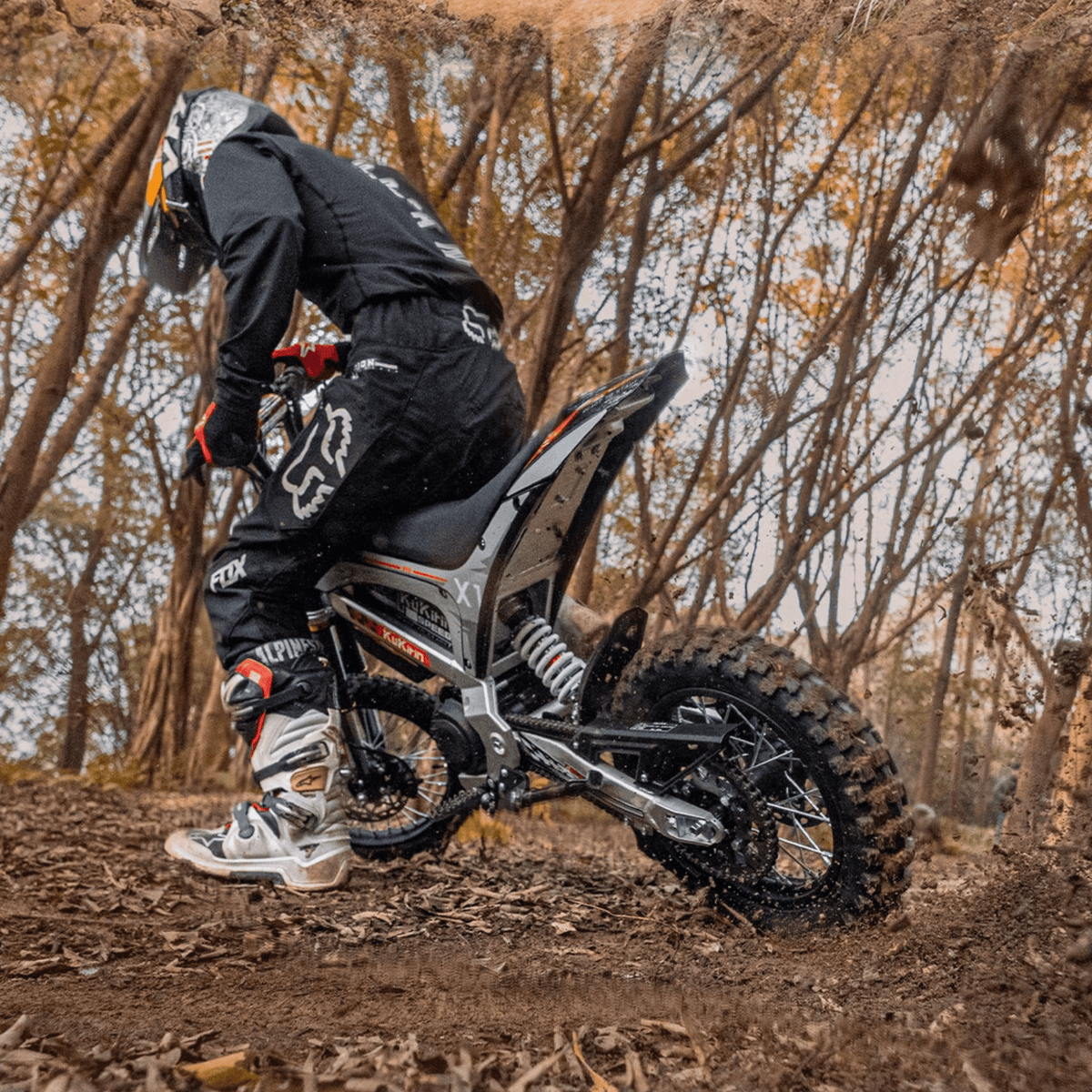 Pilote sur la moto-cross électrique KuKirin X1 en tout-terrain en forêt