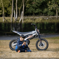 Personne assise à côté de la moto-cross électrique KuKirin X1 avec un enfant