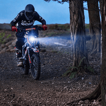 Moto-cross électrique KuKirin X1 avec éclairage allumé dans une ambiance nocturne