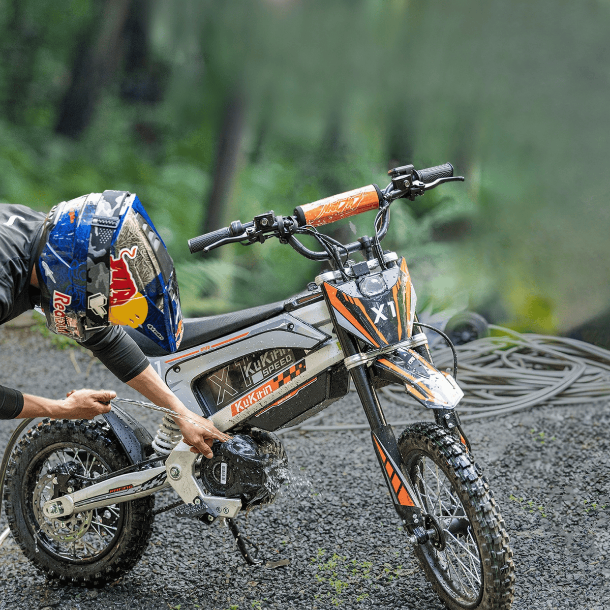 Personne debout avec la moto-cross électrique KuKirin X1 en forêt