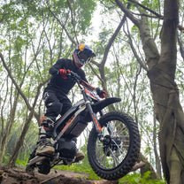 Pilote sur la moto-cross électrique KuKirin X1 en tout-terrain en forêt