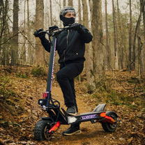 Homme debout avec la trottinette électrique Nanrobot LS7+ en forêt
