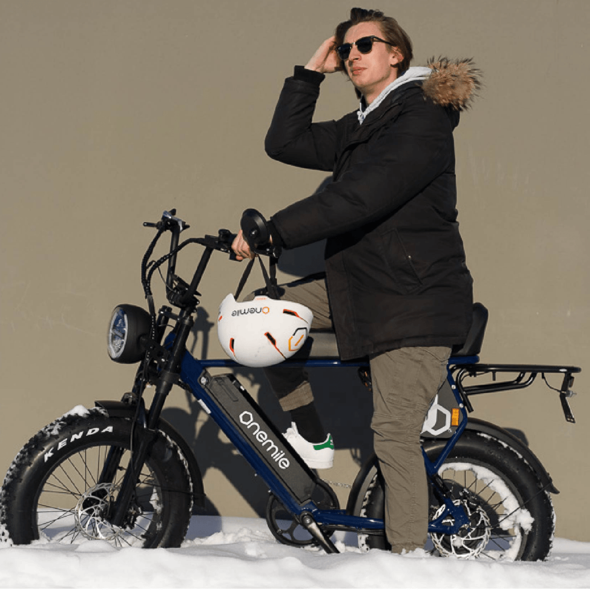Homme debout avec le vélo électrique fat bike Onemile P40 Pro dans un décor hivernal au soleil