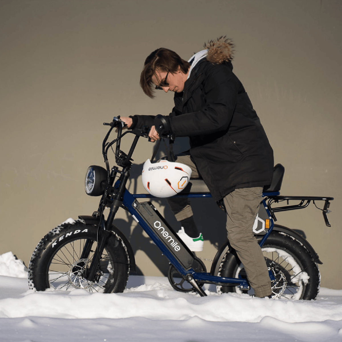 Homme debout avec le vélo électrique fat bike Onemile P40 Pro avec un casque dans un décor hivernal