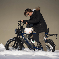 Homme debout avec le vélo électrique fat bike Onemile P40 Pro avec un casque dans un décor hivernal