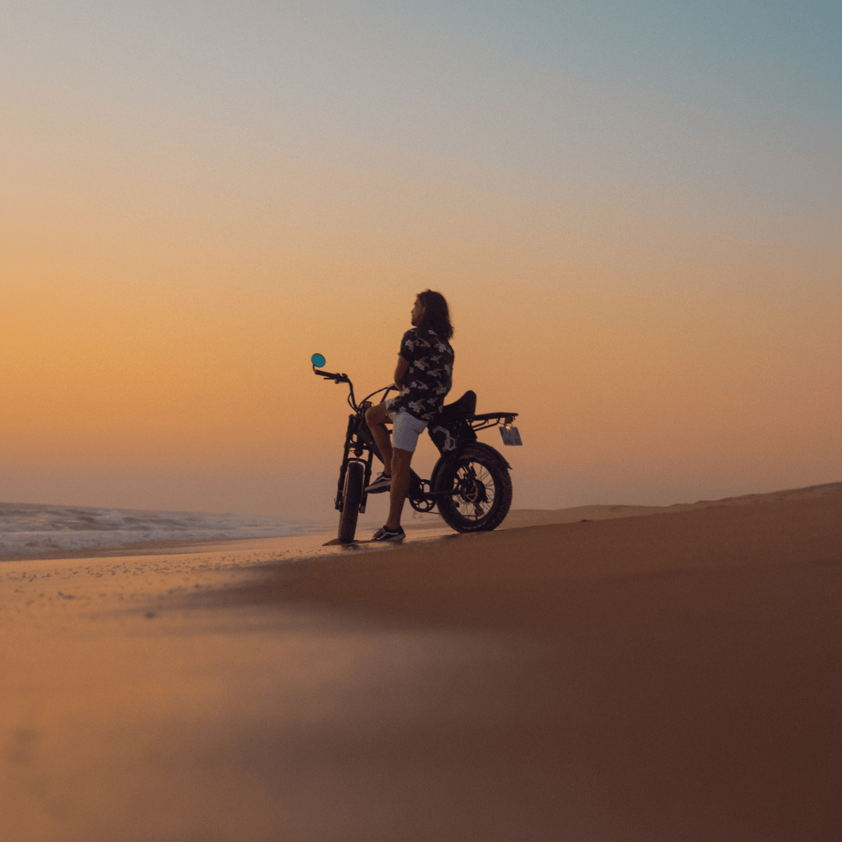 Personne roulant sur le vélo électrique fat bike Onemile P40 Pro au coucher du soleil