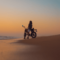 Personne roulant sur le vélo électrique fat bike Onemile P40 Pro au coucher du soleil