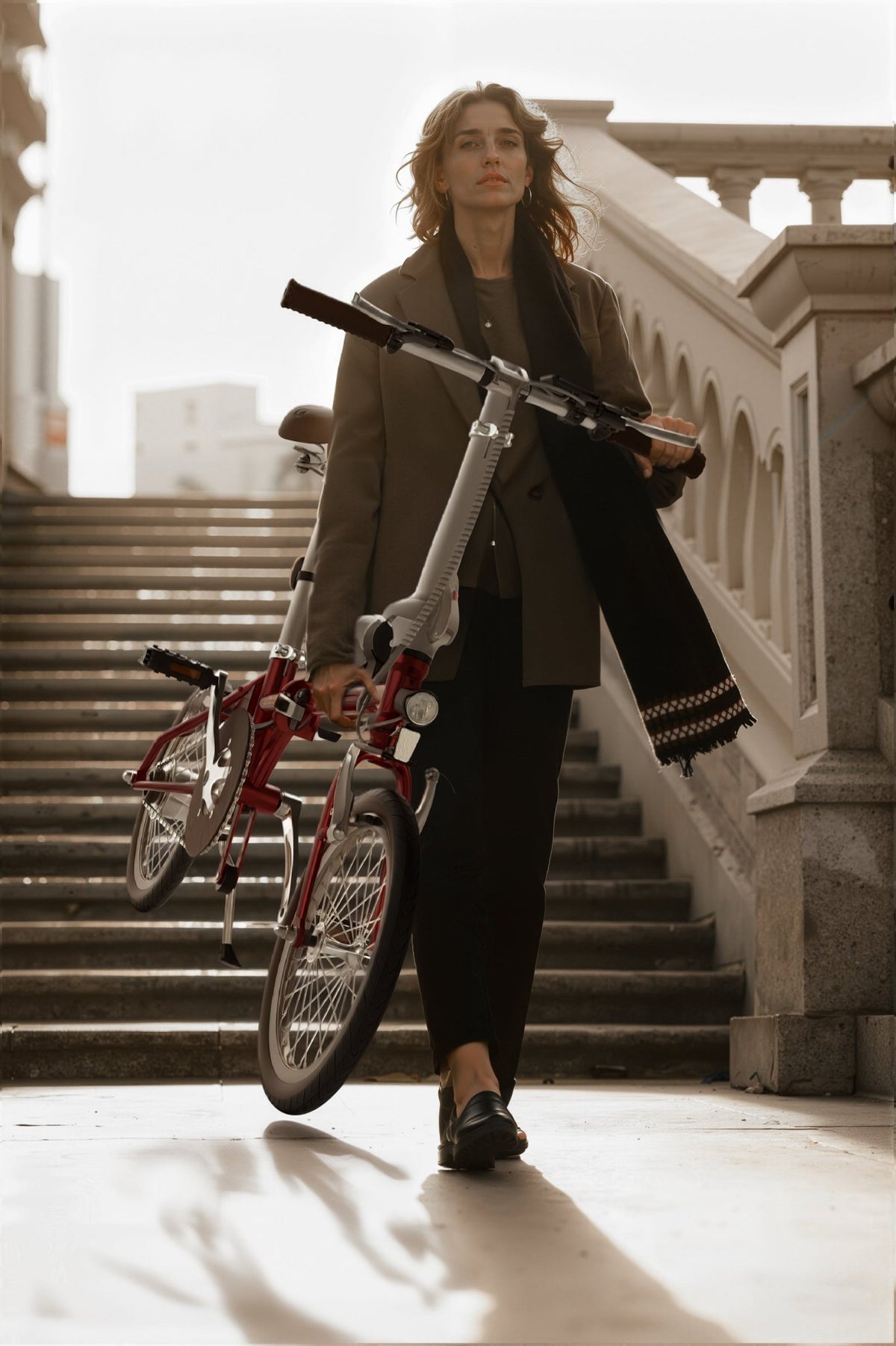 Femme debout avec le vélo électrique pliant OneSport OT02 en intérieur