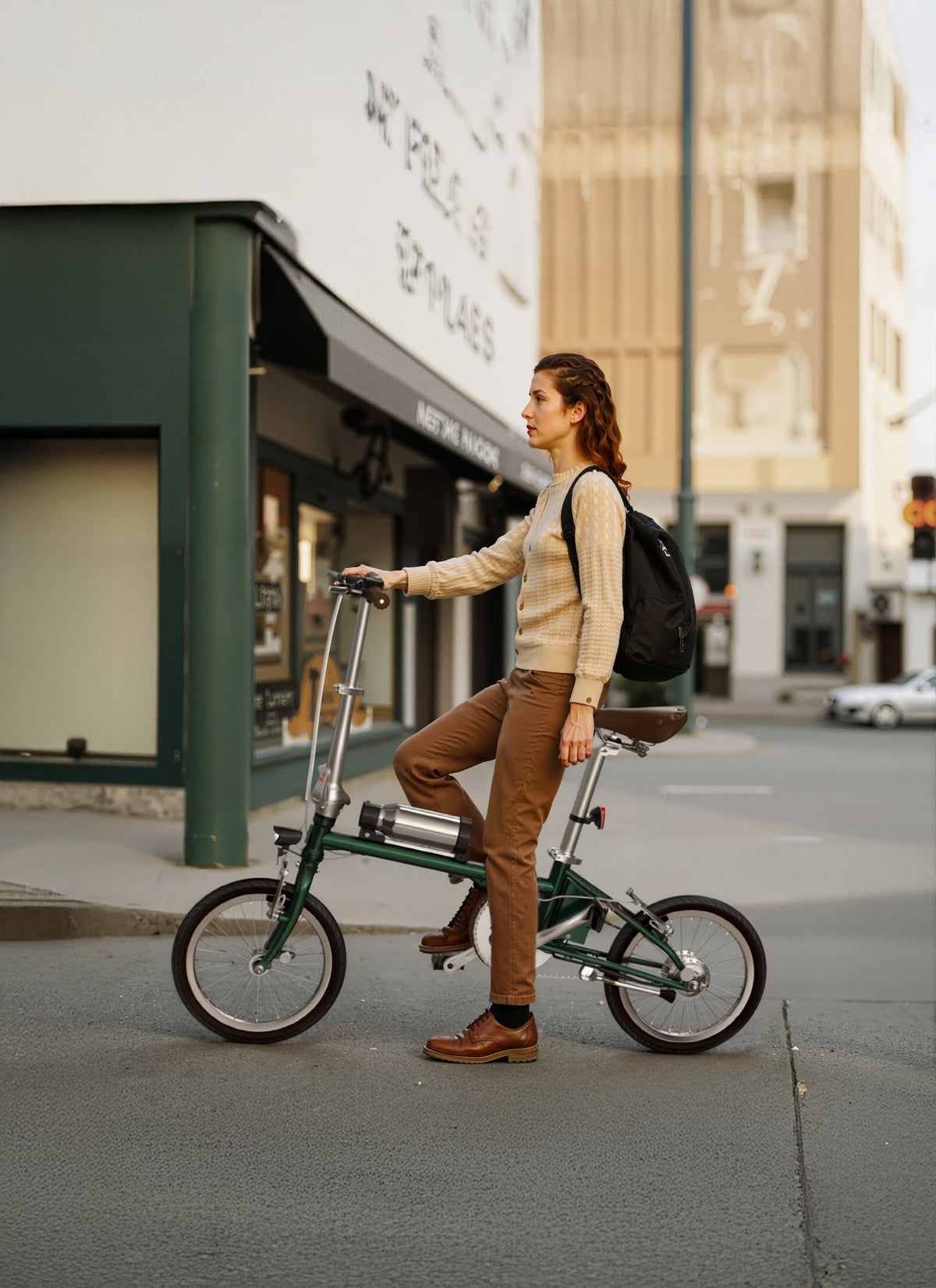 Femme debout avec le vélo électrique pliant OneSport OT02 en cours de pliage dans une rue