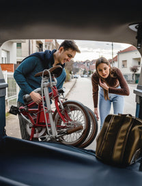 Vélo électrique pliant OneSport OT02 plié dans le coffre d'une voiture