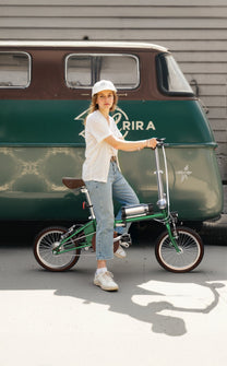 Femme debout avec le vélo électrique pliant OneSport OT02 dans une rue