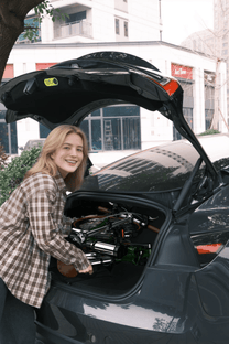 Vélo électrique pliant OneSport OT02 Pro plié dans le coffre d'une voiture coloris vert