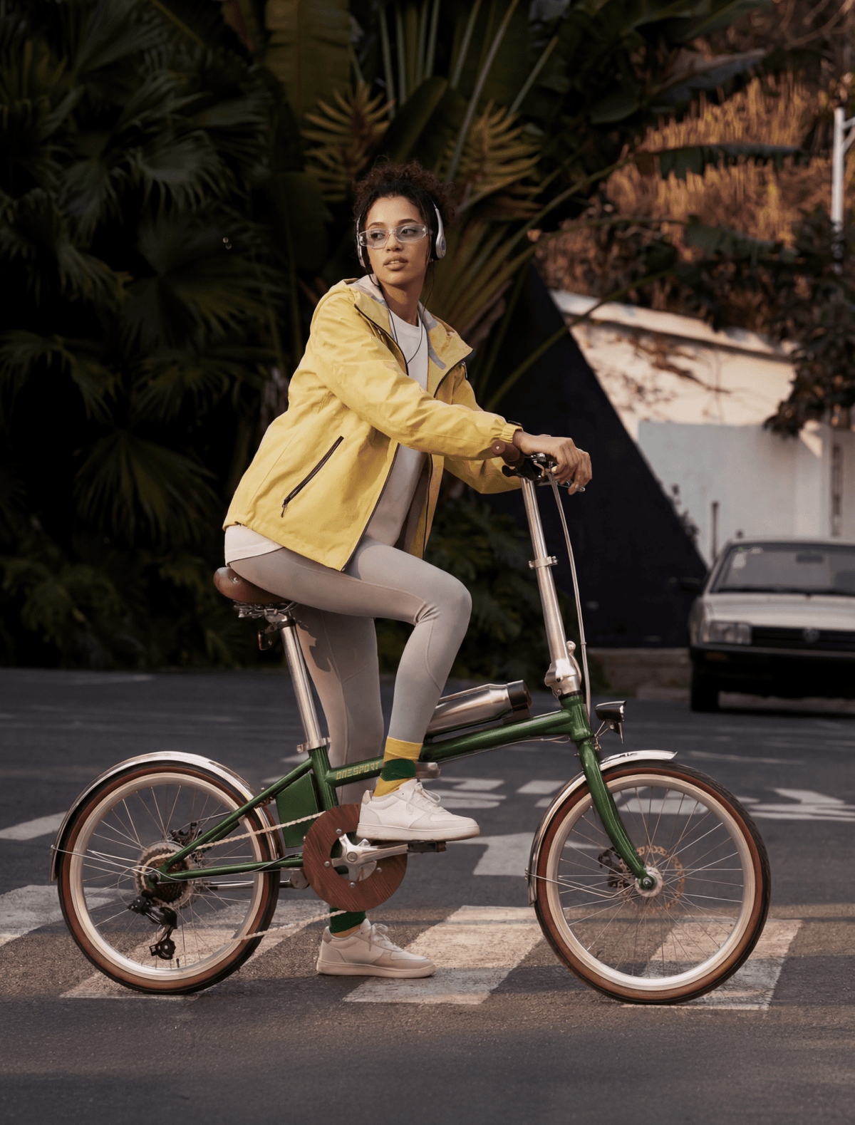 Femme roulant sur le vélo électrique pliant OneSport OT02 Pro coloris vert dans une rue