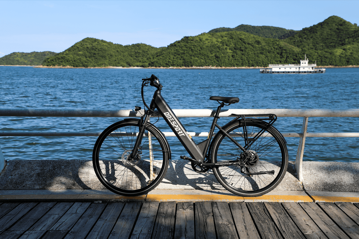 Vélo électrique OneSport OT12 vu de profil coloris noir garé au bord de la mer