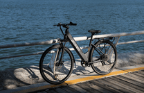 Vélo électrique OneSport OT12 vu de trois-quarts avant coloris noir au coucher du soleil