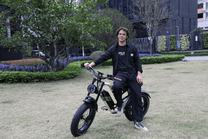 Homme debout avec le vélo électrique fat bike OneSport W66 sur une pelouse