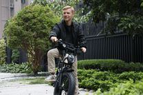 Homme assis sur le vélo électrique fat bike OneSport W66 dans une rue